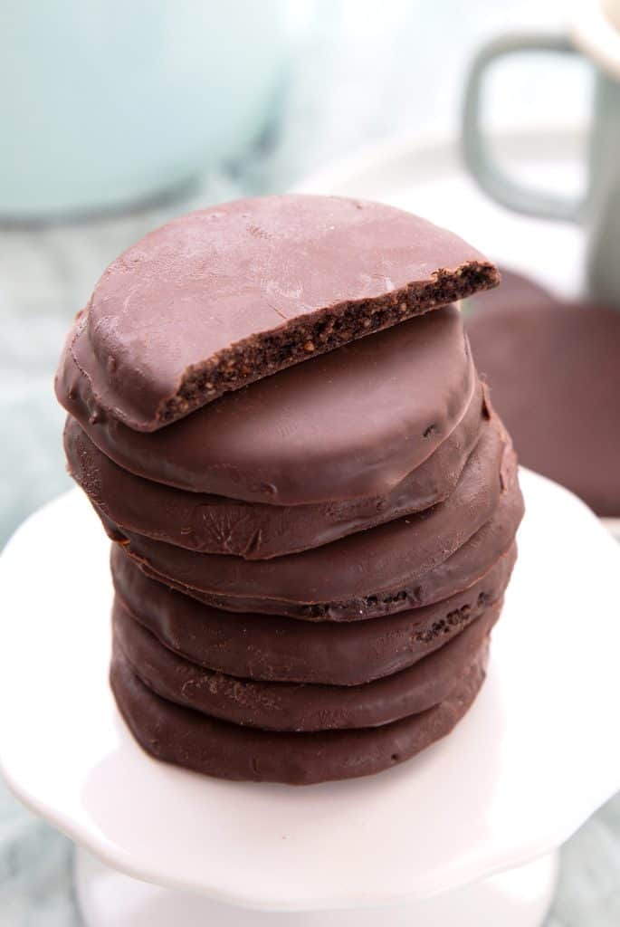 A stack of Keto Thin Mints on a white cupcake stand, with the top one broken open.