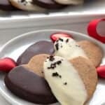 Chocolate dipped keto shortbread cookies on a white plate on a white table.