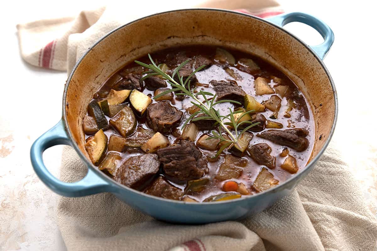 A blue Dutch oven filled with hearty keto beef stew.