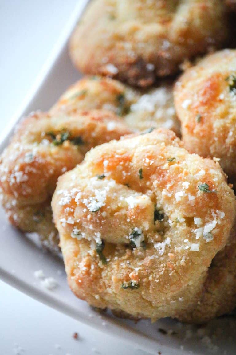 A close up shot of keto garlic knots on a white serving platter.