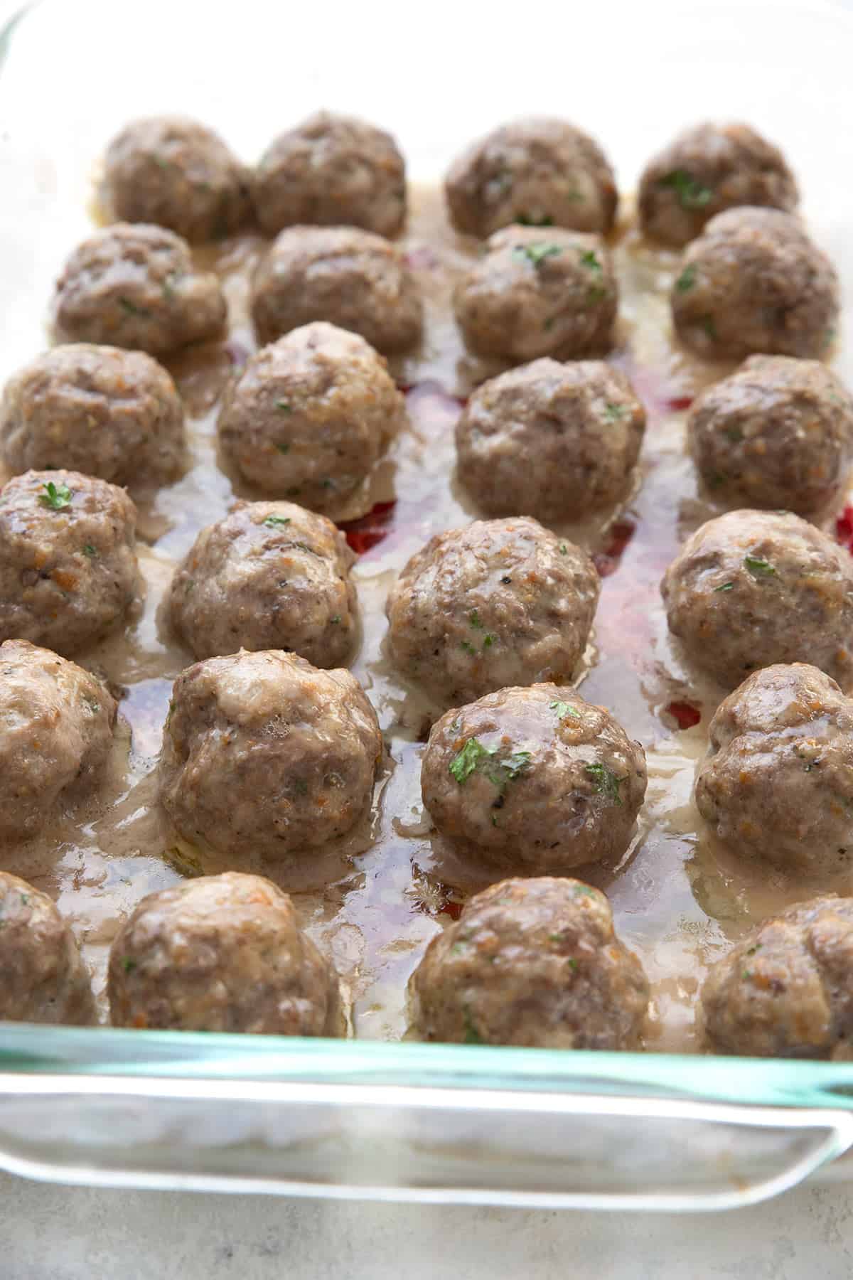 Baked keto meatballs in a glass baking dish.