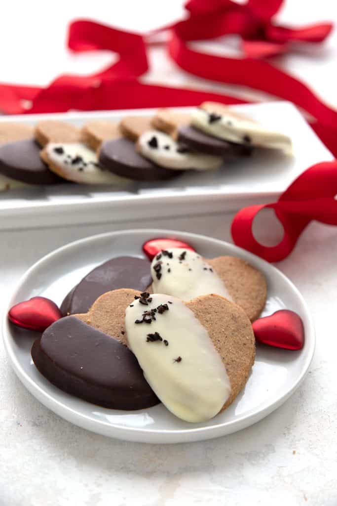 Heart-shaped keto shortbread cookies surrounded by Valentine's decorations.