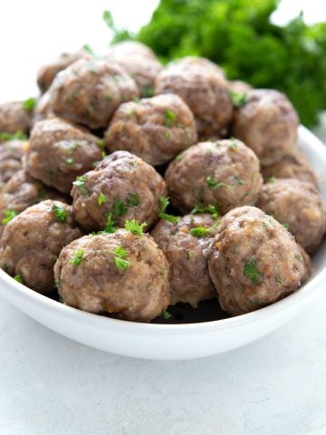 A white oval dish filled with keto meatballs for meal prep.