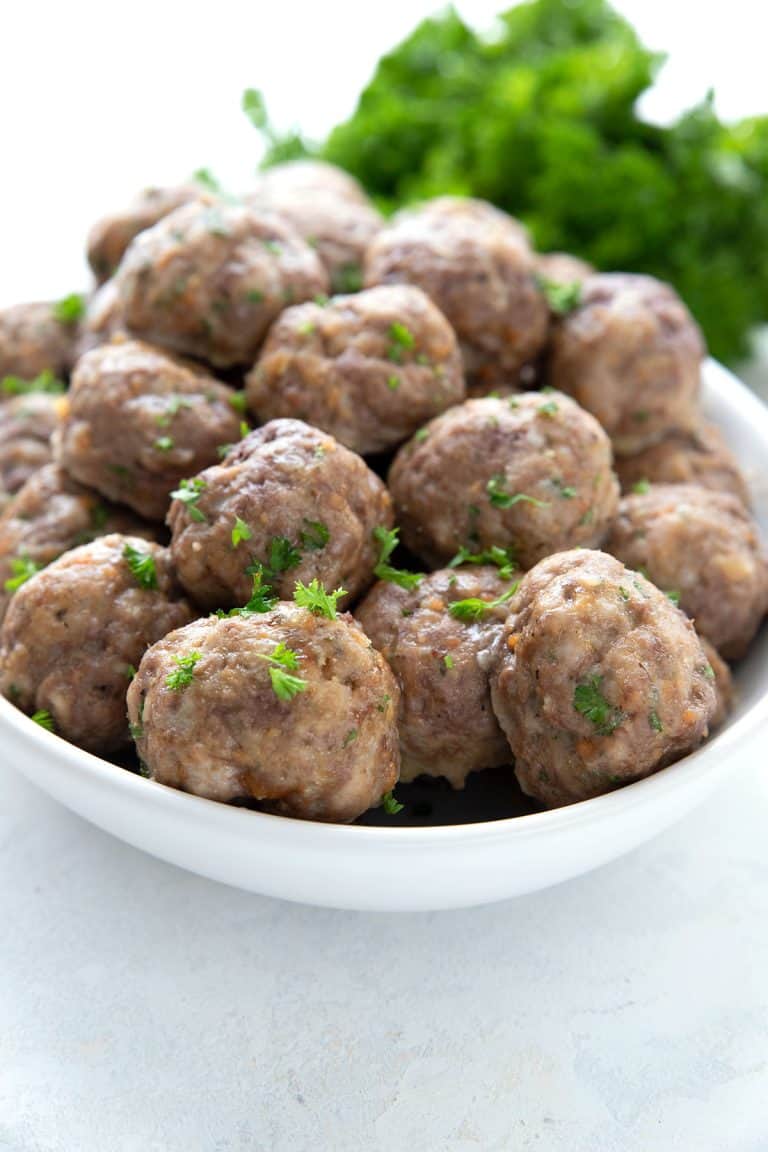 A white oval dish filled with keto meatballs for meal prep.