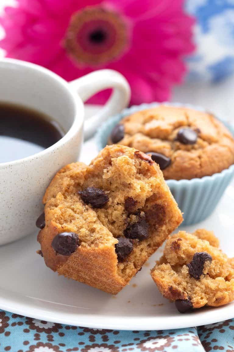 Close up shot of a keto peanut butter muffin broken open to show the inside with chocolate chips.