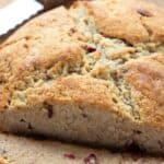 Titled image of a loaf of keto Irish soda bread on a cutting board with several slices cut out.