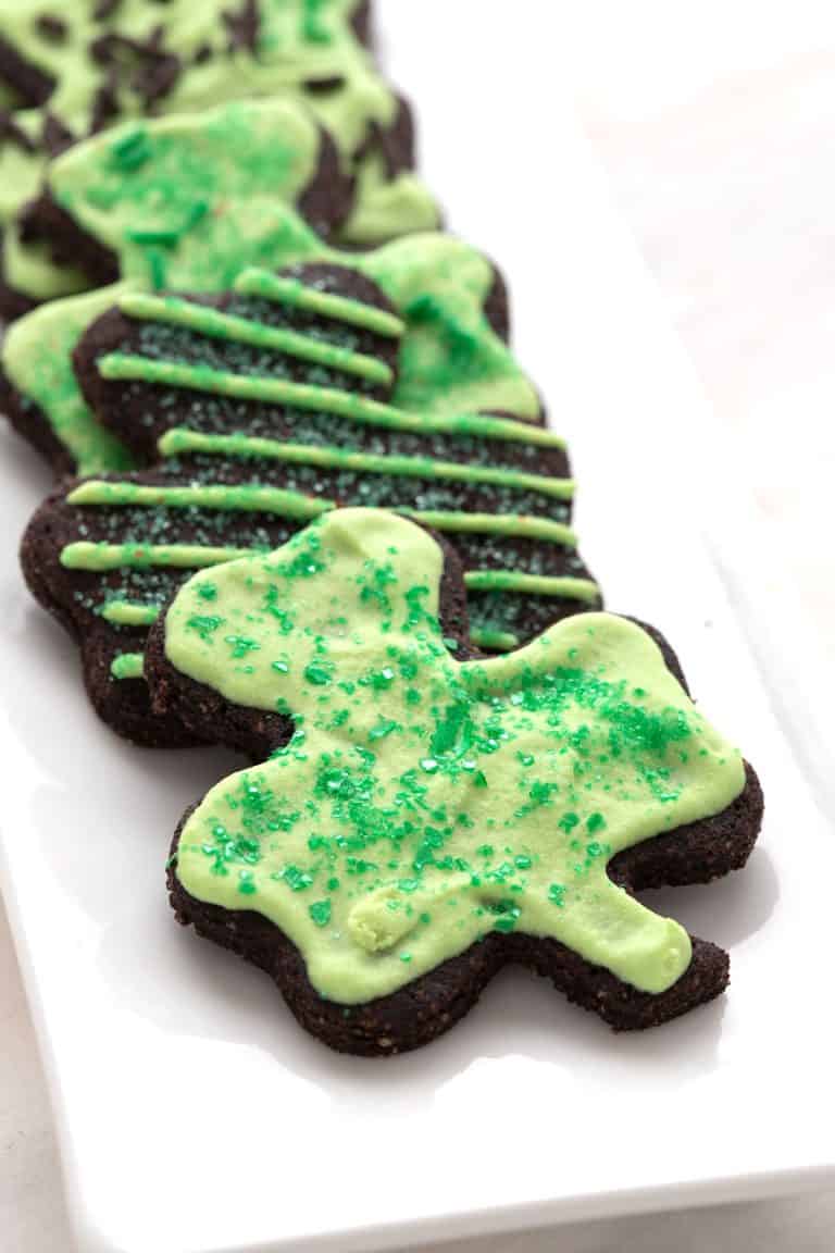 Keto shamrock shaped cookies on a white platter.