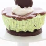 Titled image of a Keto Thin Mint Cheesecake on a white cupcake stand.