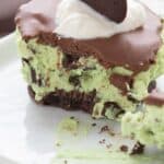 Close up shot of a Keto Thin Mint Cheesecake on a white plate with a forkful taken out of it.