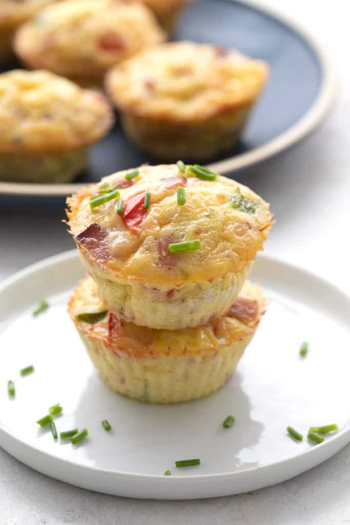 Two Denver omelet muffins stacked on each other with chives on top.