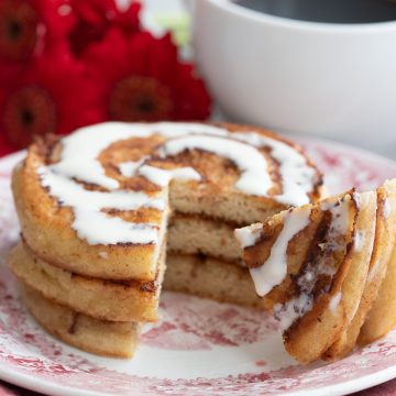 A stack of cinnamon roll pancakes with a forkful taken out of it.