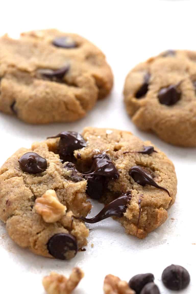 A close up shot of a keto chocolate chip cookie broken apart, with gooey warm chocolate chips inside.