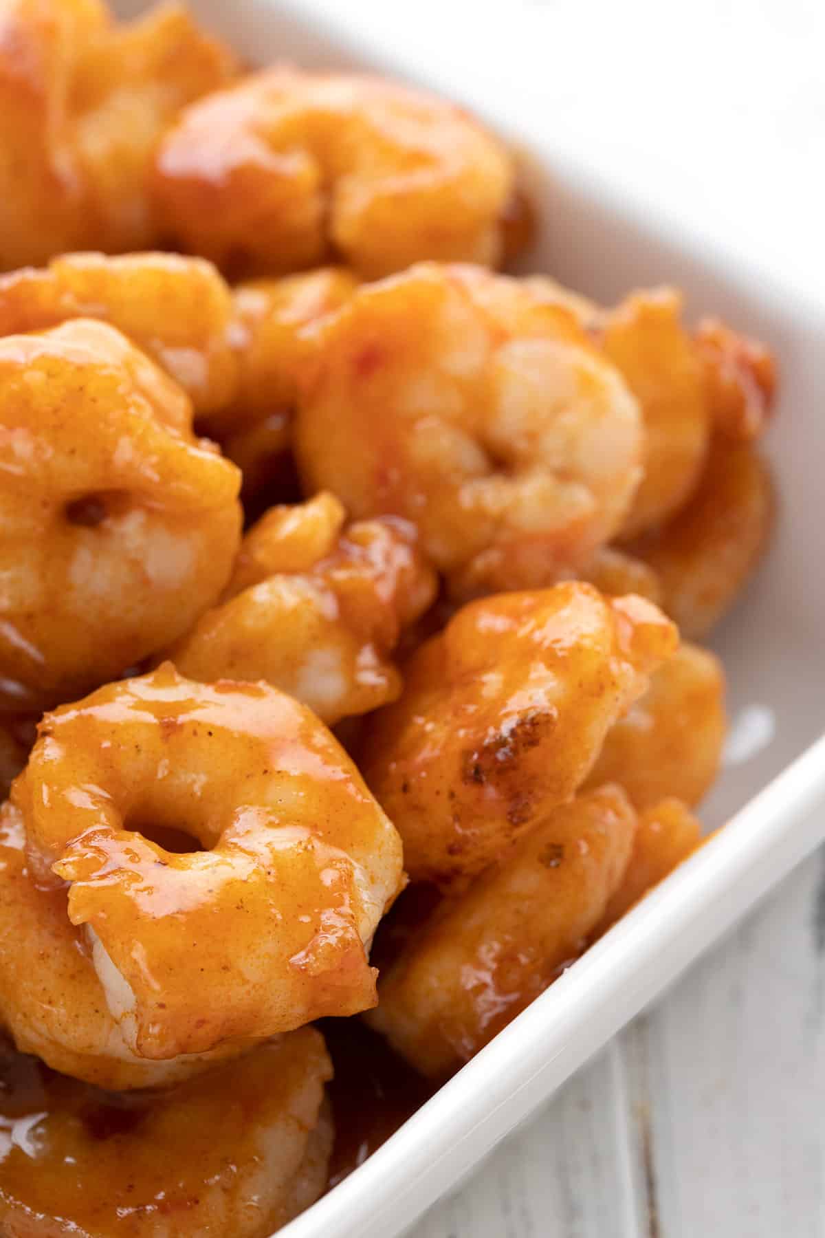 Close up shot of easy Buffalo Shrimp in a white ceramic serving dish.