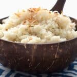 Titled image of a coconut shell bowl filled with Keto Coconut Cauliflower Rice.