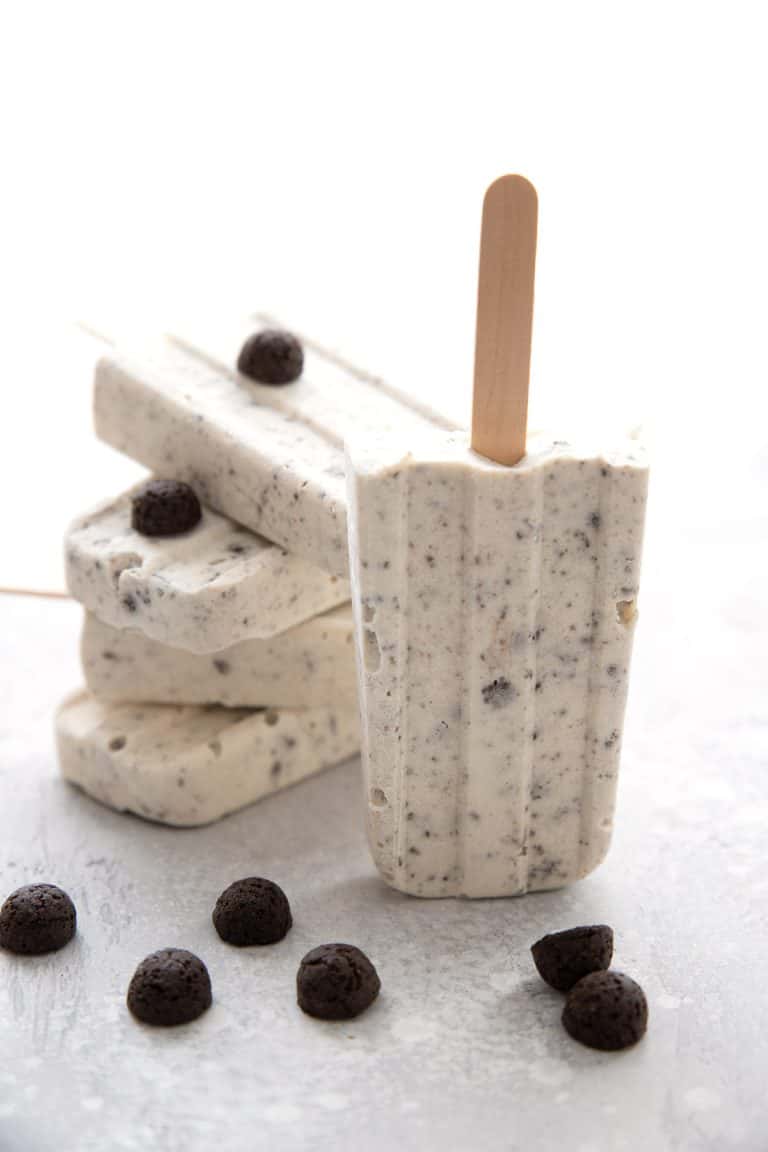 Cookies and Cream Popsicles in a pile on a grey table.