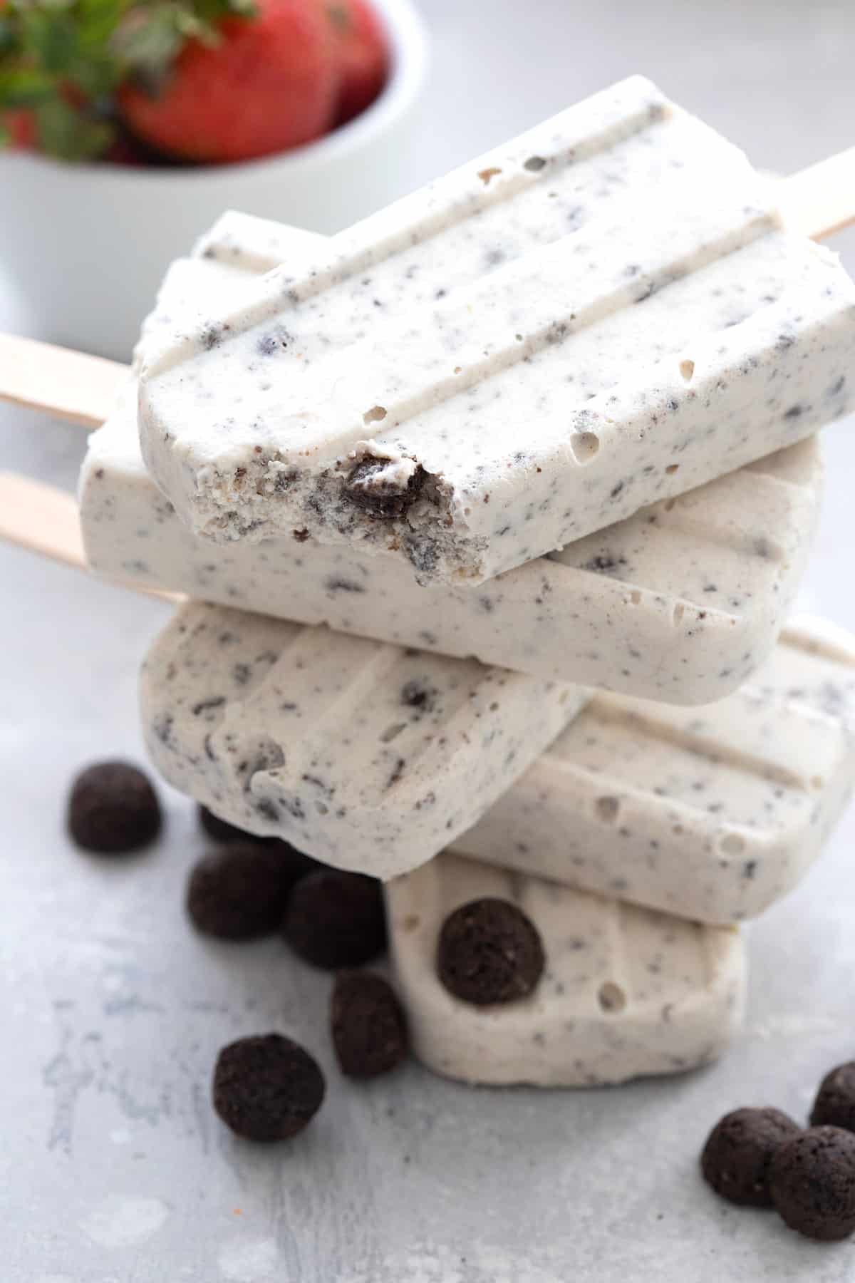 Close up shot of a stack of keto cookies and cream popsicles with a bite taken out of the top one.