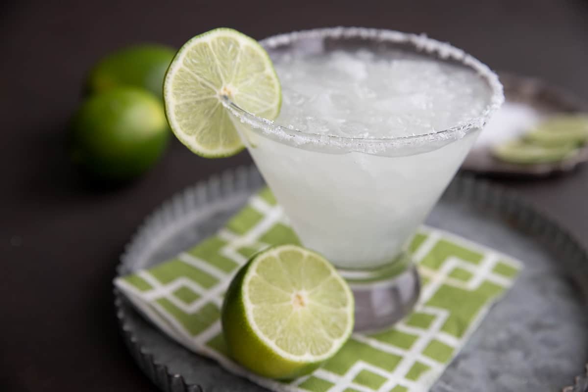 A sugar-free margarita on the rocks, on a metal tray with a green napkin.