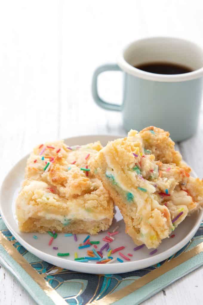 Two keto sugar cookie bars on a white plate over a colourful napkin.