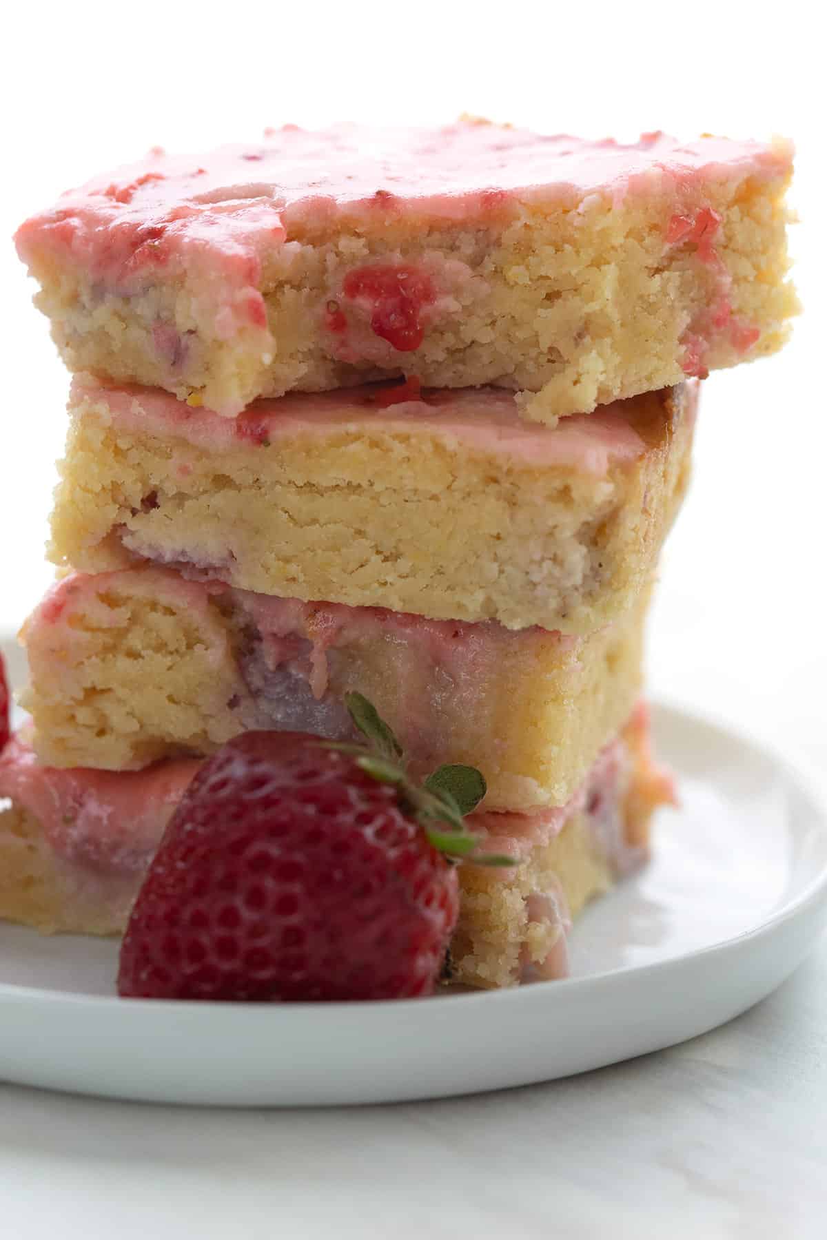 A stack of keto strawberry lemon blondies with a bite taken out of the top one.