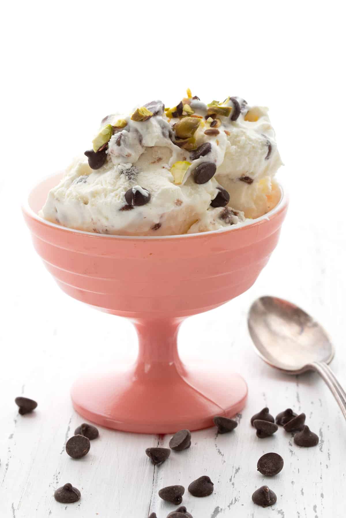A pink ice cream dish with keto cannoli ice cream, with chocolate chips strewn around.