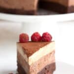 Titled image of a slice of Keto Chocolate Espresso Mousse Cake on a white plate with fresh raspberries.