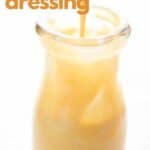 Titled Pinterest image of a spoon drizzling Keto Honey Mustard Dressing into a glass jar.