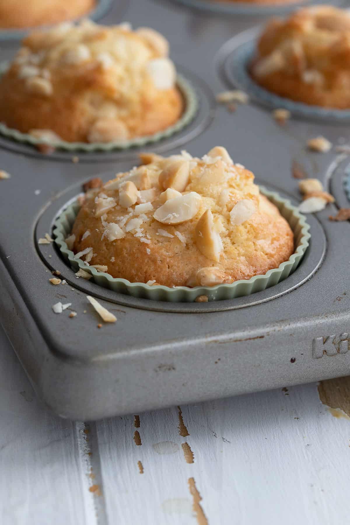 Freshly baked macadamia nut muffins in the muffin pan.
