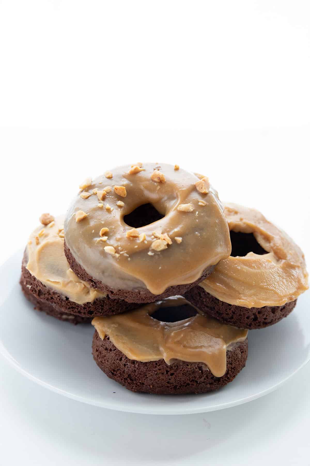 A stack of keto peanut butter donuts on a white plate.