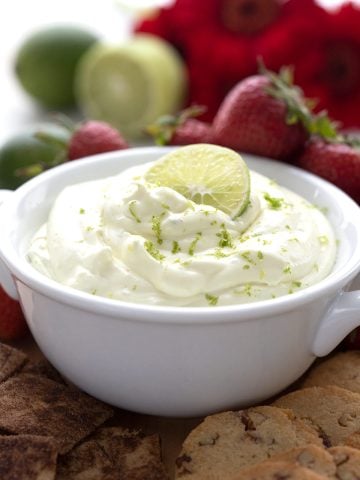 Close up shot of keto key lime pie dip with strawberries and limes in the background.