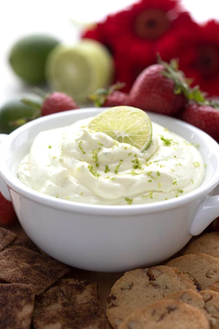 Close up shot of keto key lime pie dip with strawberries and limes in the background.