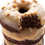 Titled Pinterest image of a stack of Keto Chocolate Donuts with peanut butter frosting, with a bite taken out of the top donut.