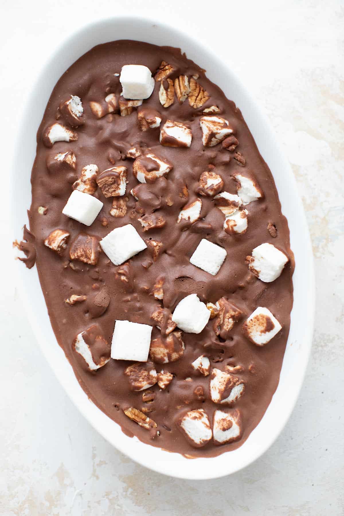 Top down image of keto rocky road ice cream in an oval white ceramic container.