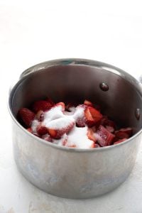 The ingredients for strawberry rhubarb sauce in a stainless steel pot.