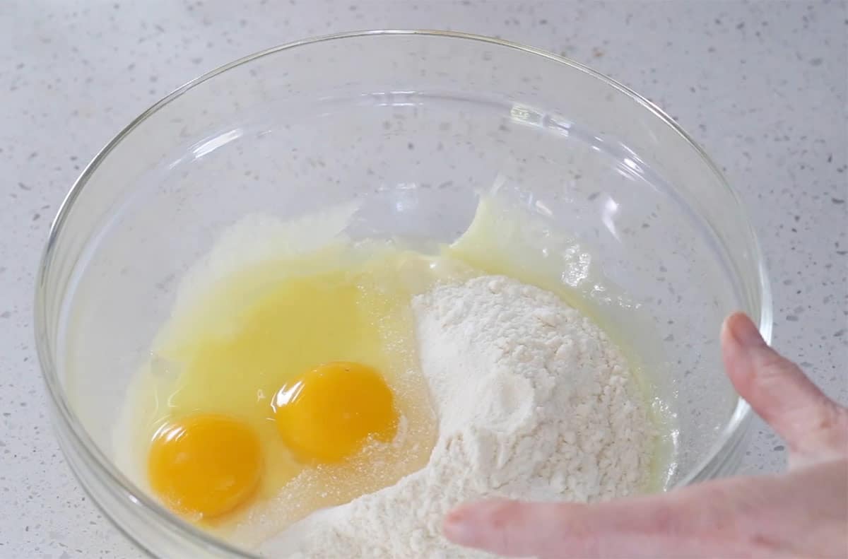 Combining the cheese, dry ingredients, and eggs.