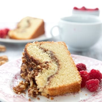 A slice of bakery style keto coffee cake on its side on a red patterned plate.