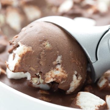 Close up shot of an ice cream scoop digging into keto rocky road ice cream.