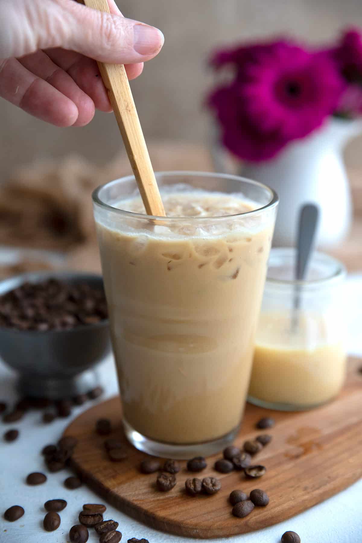 A wooden spoon stirring a glass of Vietnamese Style Keto Iced Coffee.