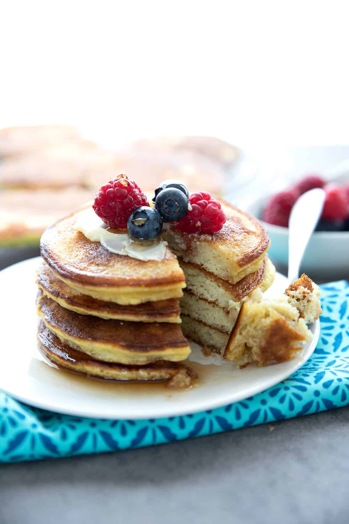 A stack of coconut flour pancakes with a forkful taken out of it.