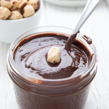 A jar of sugar free nutella with a hazelnut on top.