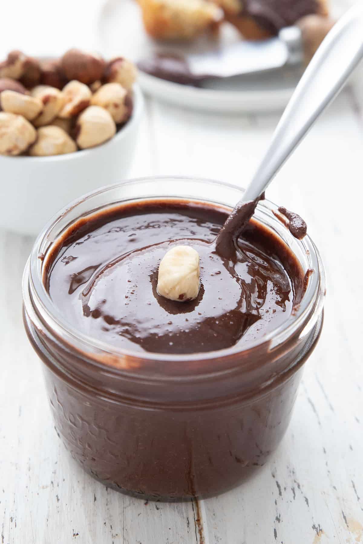 A jar of sugar free nutella with a hazelnut on top.