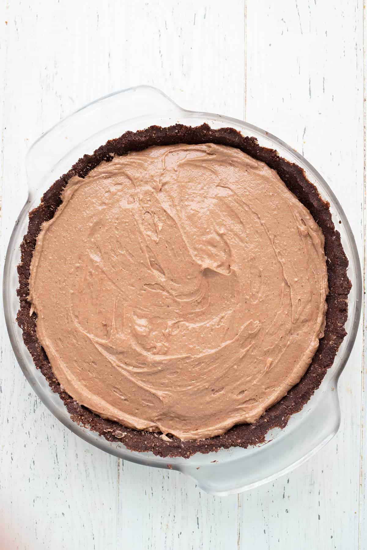 Top down image of Keto Chocolate Hazelnut Cream Pie on a white table. 