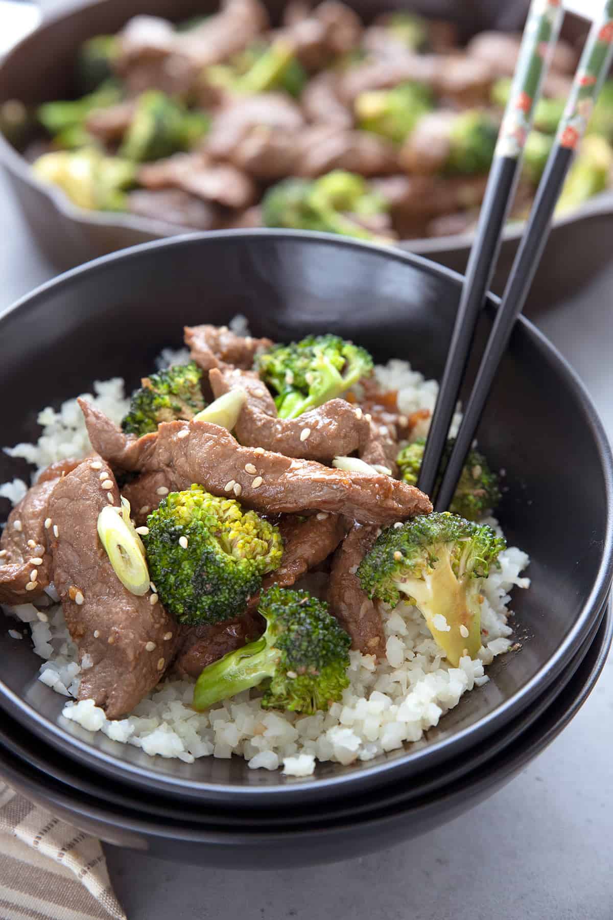 Keto Beef and Broccoli over cauliflower rice in a black bowl. 