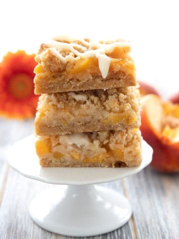A stack of keto peach cobbler bars on a white cupcake stand.