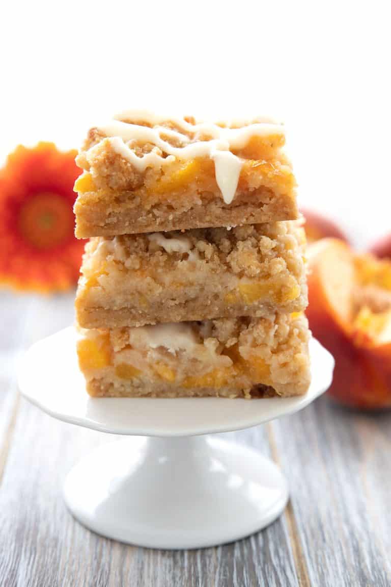 A stack of keto peach cobbler bars on a white cupcake stand.