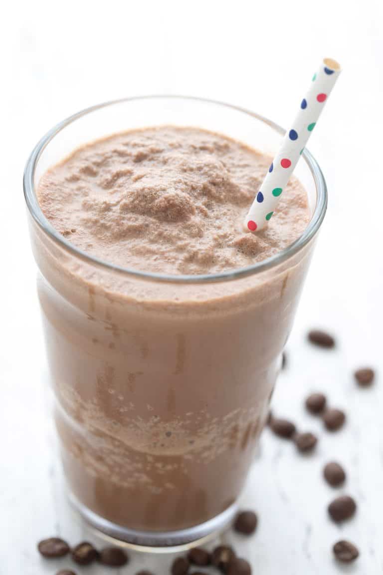 Close up shot of a Keto Coffee Protein Shake in a tall glass with a straw.