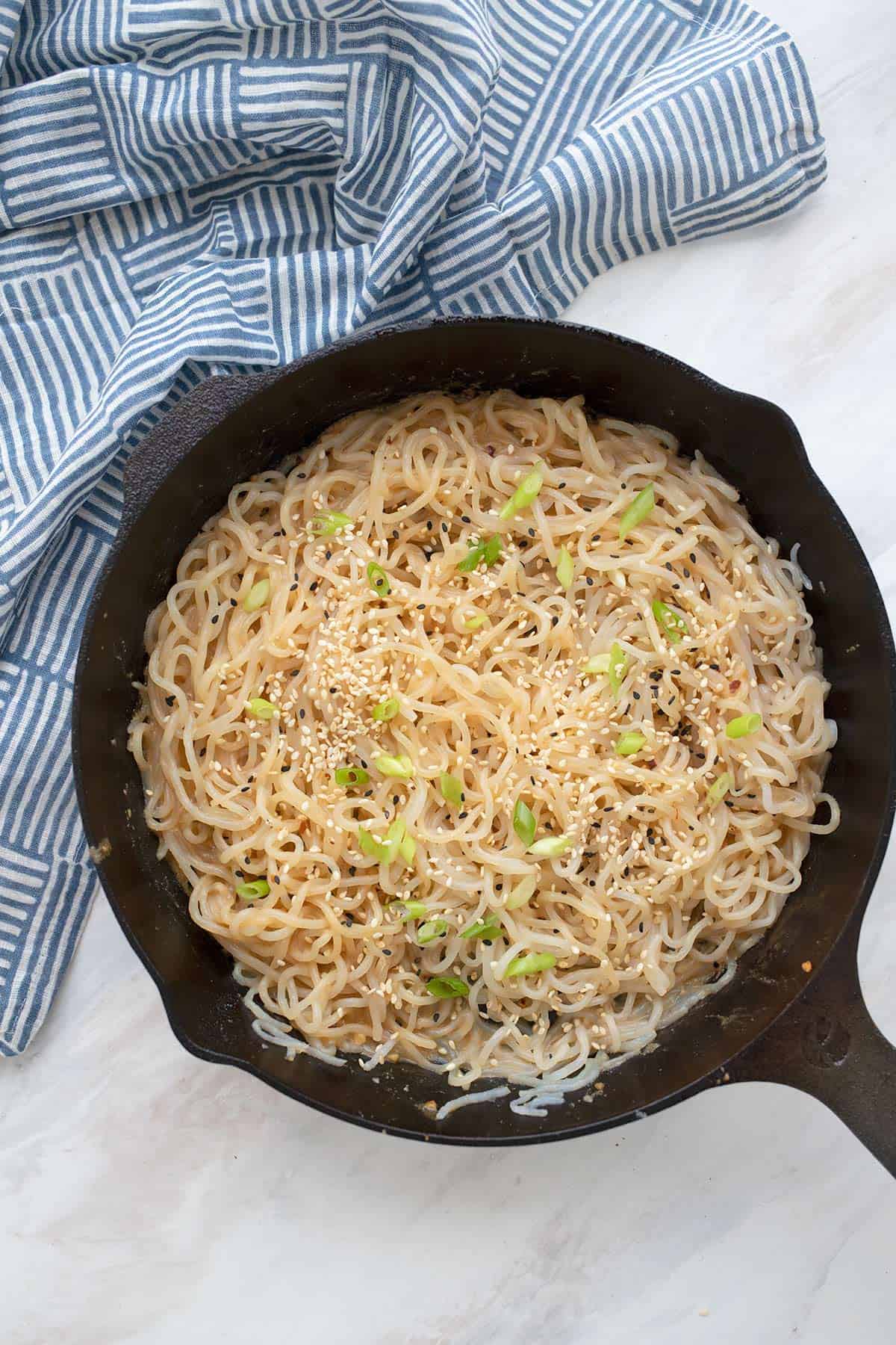 Top down image of a cast iron pan full of Keto Sesame Noodles.