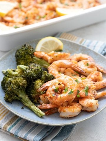 Parmesan Garlic Baked Shrimp on a blue plate with roasted broccoli.
