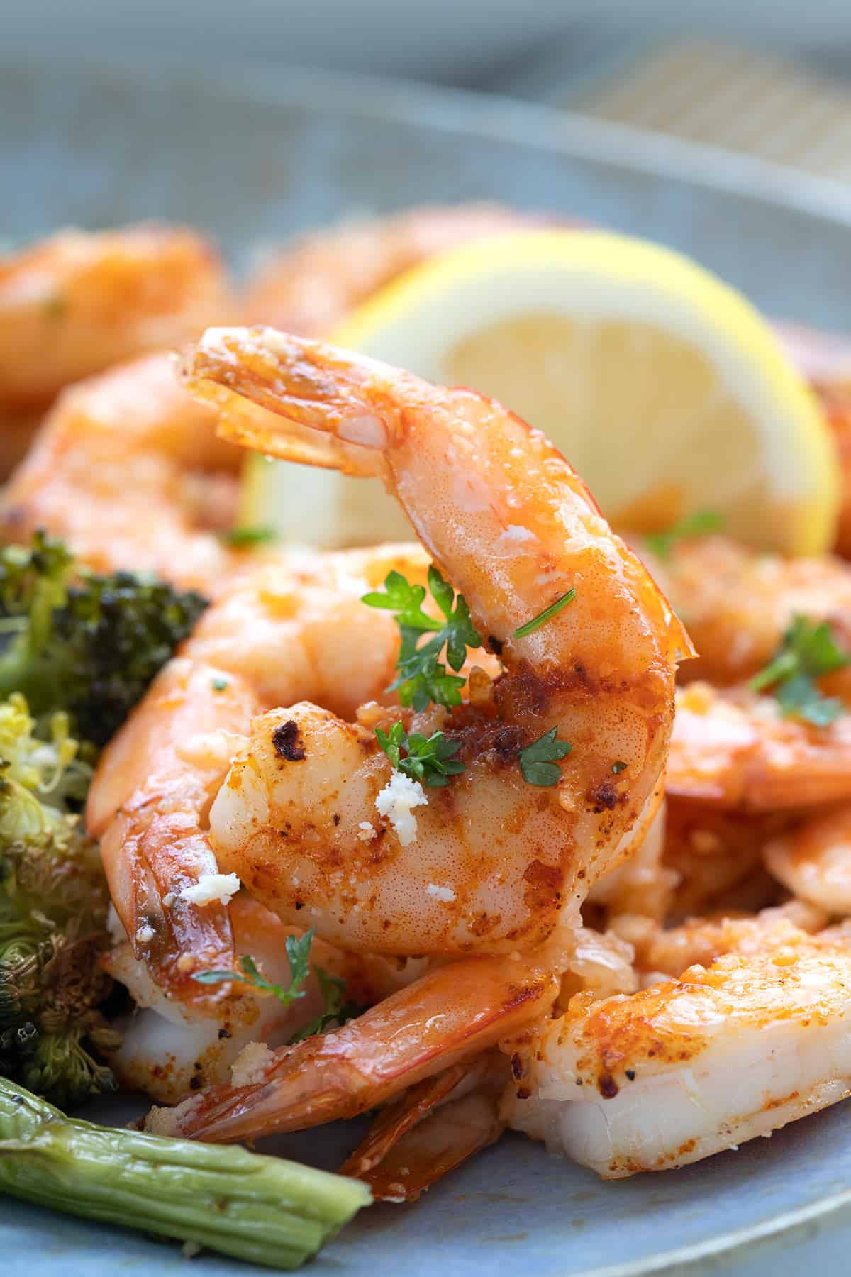 Close up shot of baked shrimp on a blue plate.