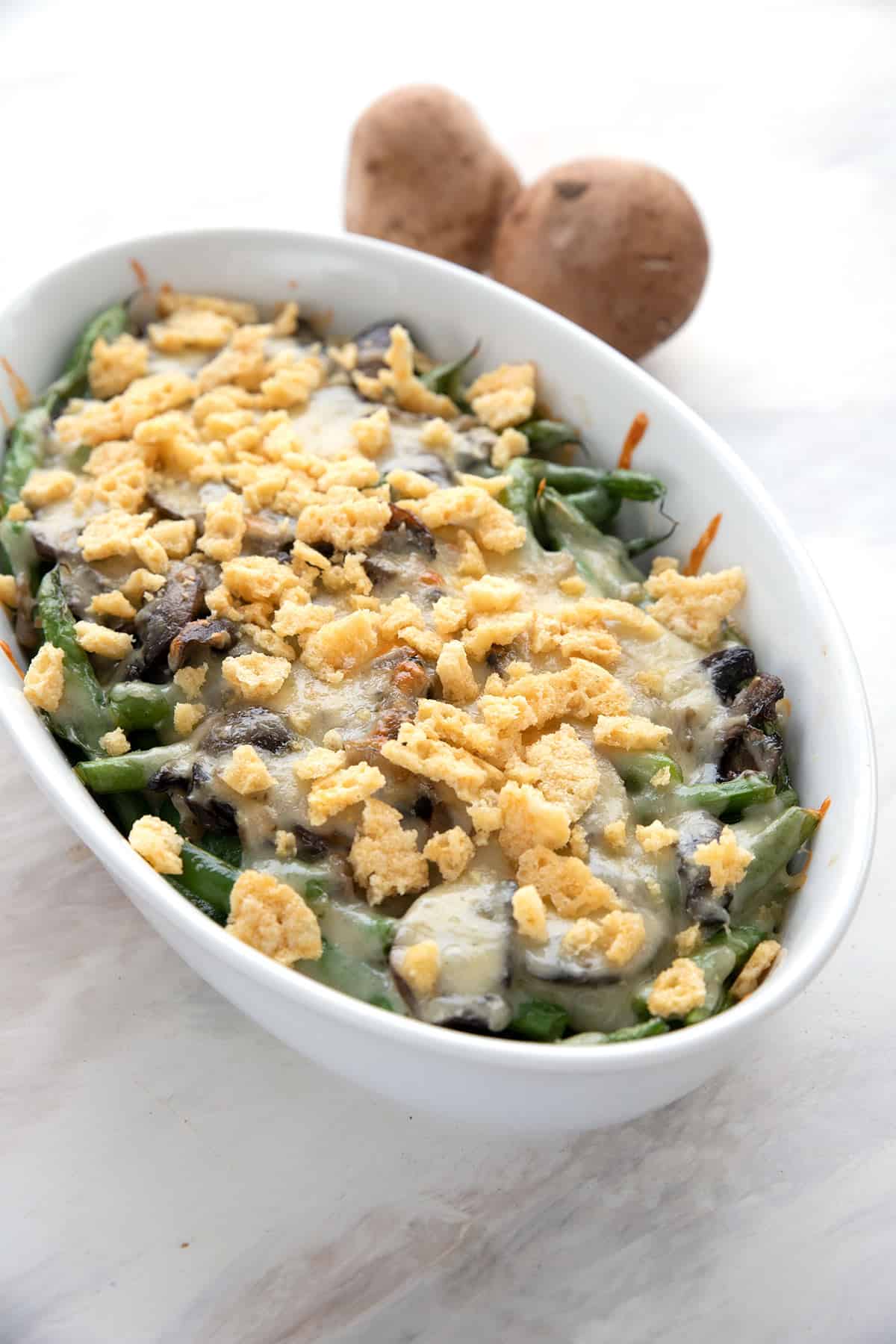 Keto Green Bean Casserole on a white table with mushrooms in the background