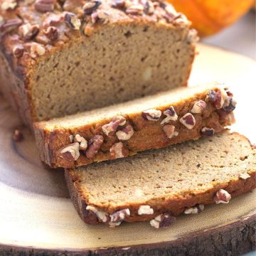 Keto pumpkin bread sliced on a wooden cutting board.